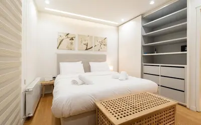a bedroom with a large white bed and a table at Parkside Kolonaki in Athens
