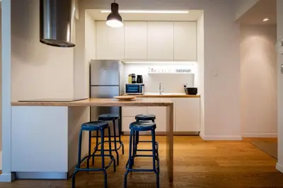a kitchen with a counter with stools around it at Parkside Kolonaki in Athens
