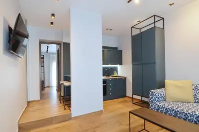 a living room with a couch and a dining room at Modern two bedroom apartment Stili Olympioy Dios in Athens