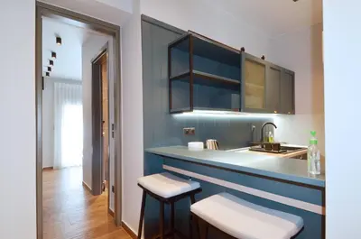 a kitchen with blue walls and a sink and stools at Modern two bedroom apartment Stili Olympioy Dios in Athens