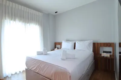 a bedroom with a large white bed with a window at Modern two bedroom apartment Stili Olympioy Dios in Athens