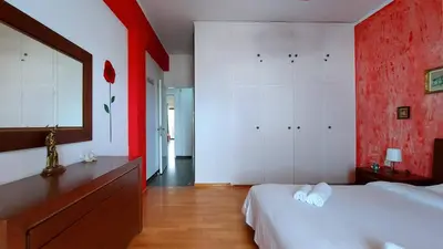 a bedroom with red and white walls and a bed at Cholargos a Spacious 2BR apartment with great view in Athens