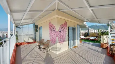 a balcony with chairs and a painting on the wall at A bright and relaxing penthouse on the 5th floor in Athens