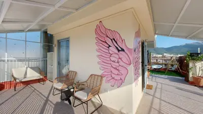 a room with two chairs and a wall with a butterfly painted on it at A bright and relaxing penthouse on the 5th floor in Athens