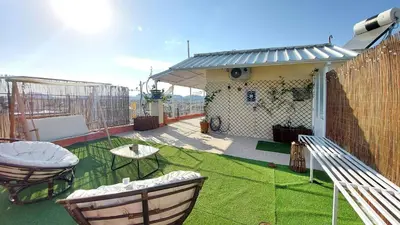 a patio with a table and chairs on a roof at A bright and relaxing penthouse on the 5th floor in Athens