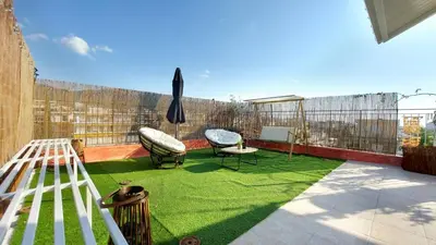 a small backyard with a green lawn on a balcony at A bright and relaxing penthouse on the 5th floor in Athens