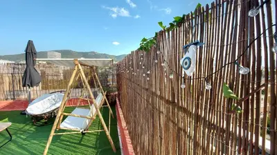 a fence with a chair and an umbrella on a balcony at A bright and relaxing penthouse on the 5th floor in Athens