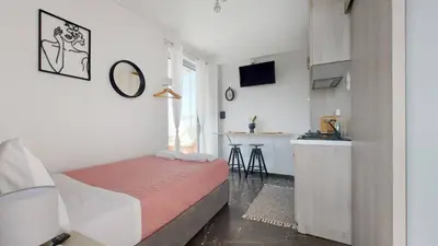 a small bedroom with a bed and a kitchen at A bright and relaxing penthouse on the 5th floor in Athens