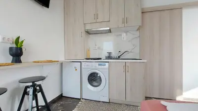 a kitchen with a washing machine and a sink at A bright and relaxing penthouse on the 5th floor in Athens