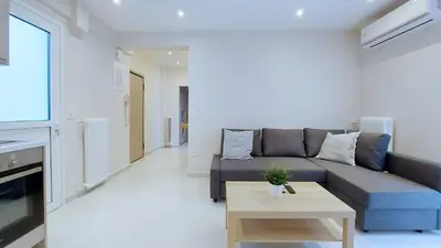 a living room with a couch and a table at A modern and bright apartment in Kolonaki in Athens