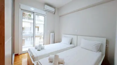 two beds in a small room with a window at A modern and bright apartment in Kolonaki in Athens