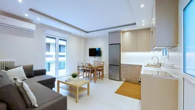 a living room and kitchen with a couch and a table at A modern and bright apartment in Kolonaki in Athens