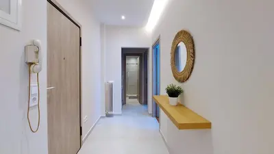 a hallway with a mirror on the wall and a table at A modern and bright apartment in Kolonaki in Athens