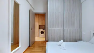 a bedroom with two beds and a door to a kitchen at A modern and bright apartment in Kolonaki in Athens