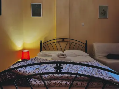 a bedroom with a bed with a lamp and a couch at Budget and private flat in Aristotelous in Athens