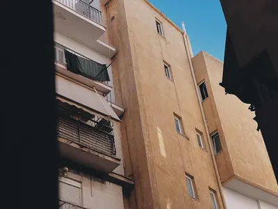 a tall brown building with windows and a balcony at Budget and private flat in Aristotelous in Athens