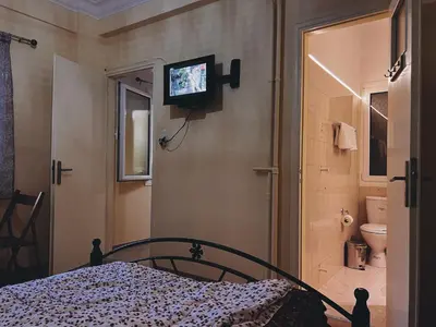 a bedroom with a bed and a tv on the wall at Budget and private flat in Aristotelous in Athens