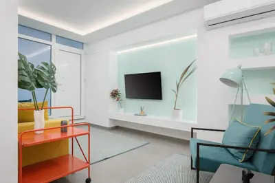 a living room with a tv on a wall at Acropolis Secret Apartment in Athens