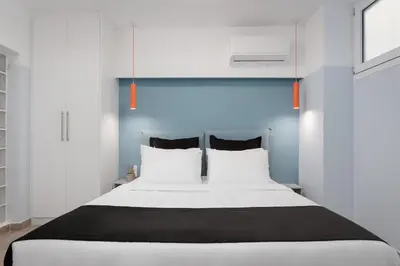 a bedroom with a large white bed with two pillows at Acropolis Secret Apartment in Athens