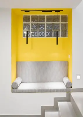 a bench in a room with a yellow wall at Acropolis Secret Apartment in Athens