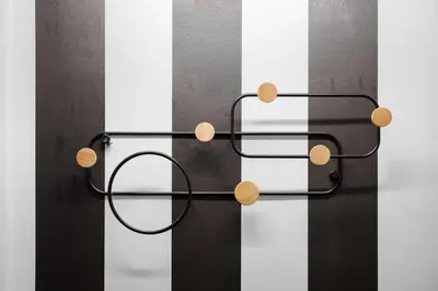 a black metal towel rack with wooden circles on it at Acropolis Secret Apartment in Athens
