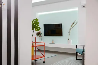 a living room with a tv and a red chair at Acropolis Secret Apartment in Athens