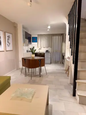 a living room with a table and a kitchen at Cozy Seaside Stay Renovated & Peaceful in Porto Rafti
