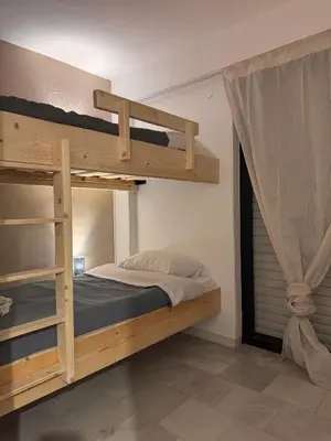 a bedroom with two bunk beds and a window at Cozy Seaside Stay Renovated & Peaceful in Porto Rafti