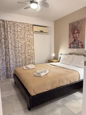 a bedroom with a large bed and a painting on the wall at Cozy Seaside Stay Renovated & Peaceful in Porto Rafti