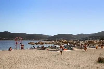 a group of people on a beach with umbrellas at Cozy Seaside Stay Renovated & Peaceful in Porto Rafti