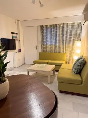 a living room with two couches and a table at Cozy Seaside Stay Renovated & Peaceful in Porto Rafti