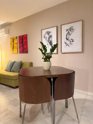 a table and chairs in a living room with a couch at Cozy Seaside Stay Renovated & Peaceful in Porto Rafti