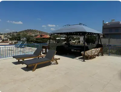 two lounge chairs and an umbrella on a patio at Aegean Home in Áyios Nikólaos