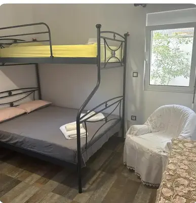 a bedroom with two bunk beds and a chair at Aegean Home in Áyios Nikólaos