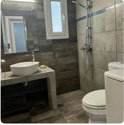 a bathroom with a sink and a toilet and a shower at Aegean Home in Áyios Nikólaos