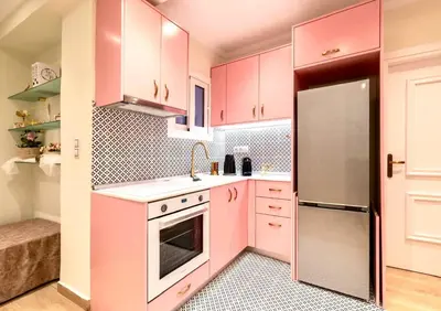 a pink kitchen with white cabinets and a refrigerator at Athens Acropolis Markella in Athens