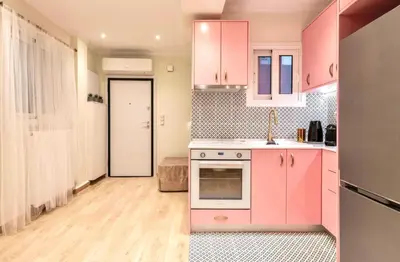 a kitchen with pink cabinets and a stove top oven at Athens Acropolis Markella in Athens