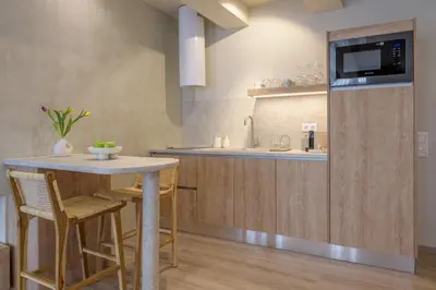 a kitchen with a counter and a table with chairs at Minimalist Oasis in Athens in Athens
