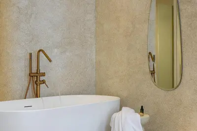 a bathroom with a tub and a sink and a mirror at Minimalist Oasis in Athens in Athens