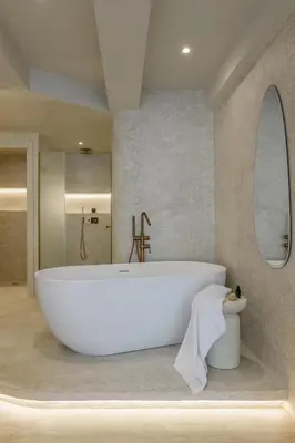 a bathroom with a large white tub and a mirror at Minimalist Oasis in Athens in Athens