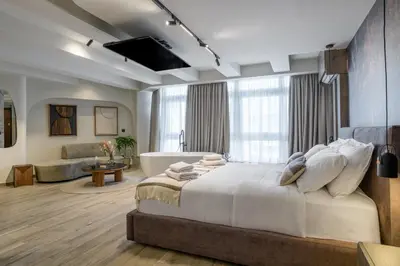 a bedroom with a large bed and a bath tub at Urban Serenity Suite in Athens in Athens