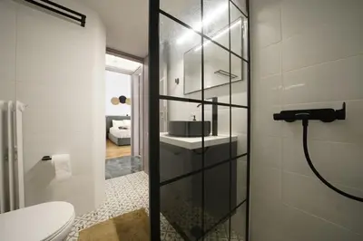 a bathroom with a toilet and a glass shower door at New Delightful Apartment in Athens