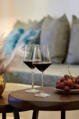 two glasses of wine on a table with grapes at New Delightful Apartment in Athens