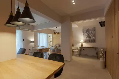 a dining room and living room with a table and chairs at Phaedrus Living Athens Metsovou Residence in Athens