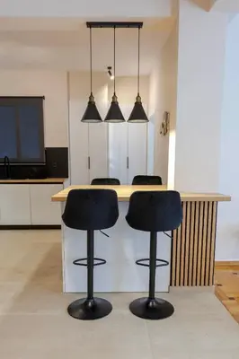 a kitchen with a table with two black bar stools at Phaedrus Living Athens Metsovou Residence in Athens