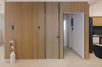 a room with a large wooden wall with a vase at Phaedrus Living Athens Metsovou Residence in Athens
