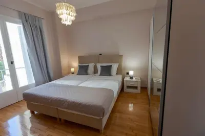 a bedroom with a large bed and a chandelier at Phaedrus Living Athens Metsovou Residence in Athens