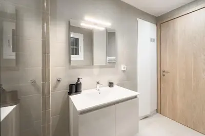 a bathroom with a white sink and a shower at New Central Apt in Kolonaki in Athens