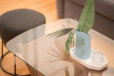 a glass table with a vase with a plant in it at New Central Apt in Kolonaki in Athens
