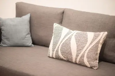 a pillow sitting on a couch with two pillows at New Central Apt in Kolonaki in Athens